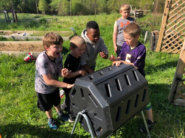 photo Children at Deep Roots spin their food scrap compost tumbler